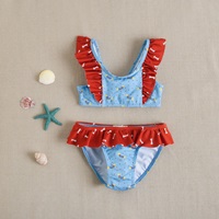 Imagen de Bikini de niña en color azul con volante rojo estampado 