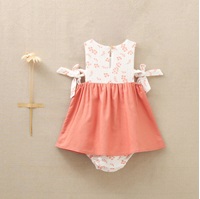 Imagen de Vestido de bebé niña en color coral combinado con bambula blanca con detalle de flores