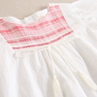 Imagen de Vestido de niña blanco y tejido de rayas coral en pechera