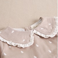 Imagen de Vestido de bebé niña beige con gotas de agua blancas y cuello bebé