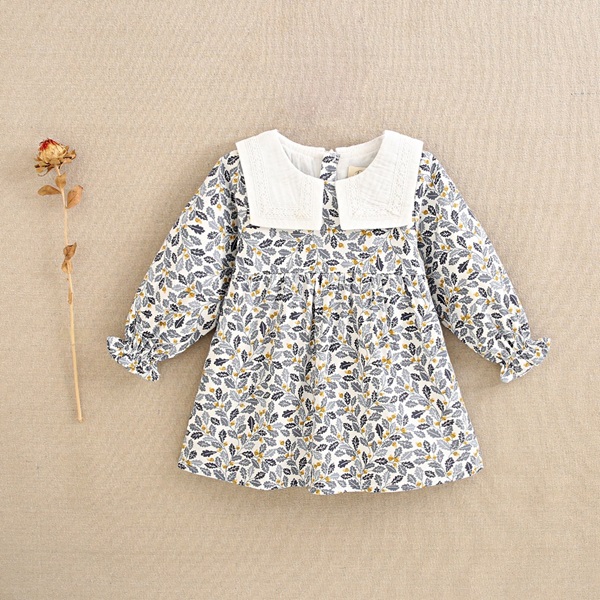 Imagen de Vestido de bebé niña con estampado de hojas azul y mostaza con cuello babero blanco