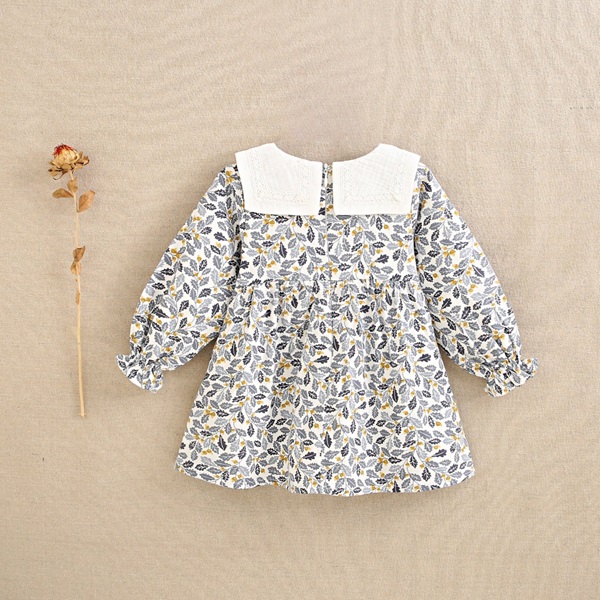 Imagen de Vestido de bebé niña con estampado de hojas azul y mostaza con cuello babero blanco