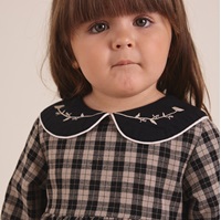 Imagen de Vestido de bebé niña en cuadros bicolor beige tostado y negro con bordado en cuello